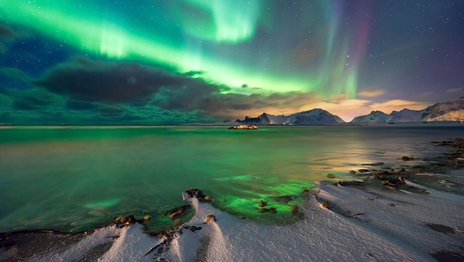 The Aurora Borealis illuminating a snowy landscape